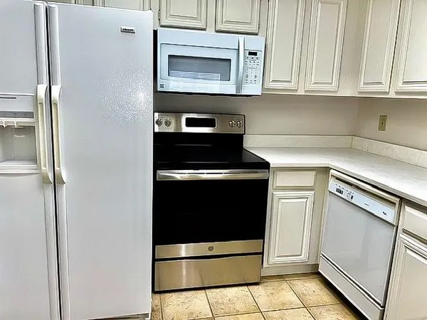 a kitchen with white cabinets and black appliances