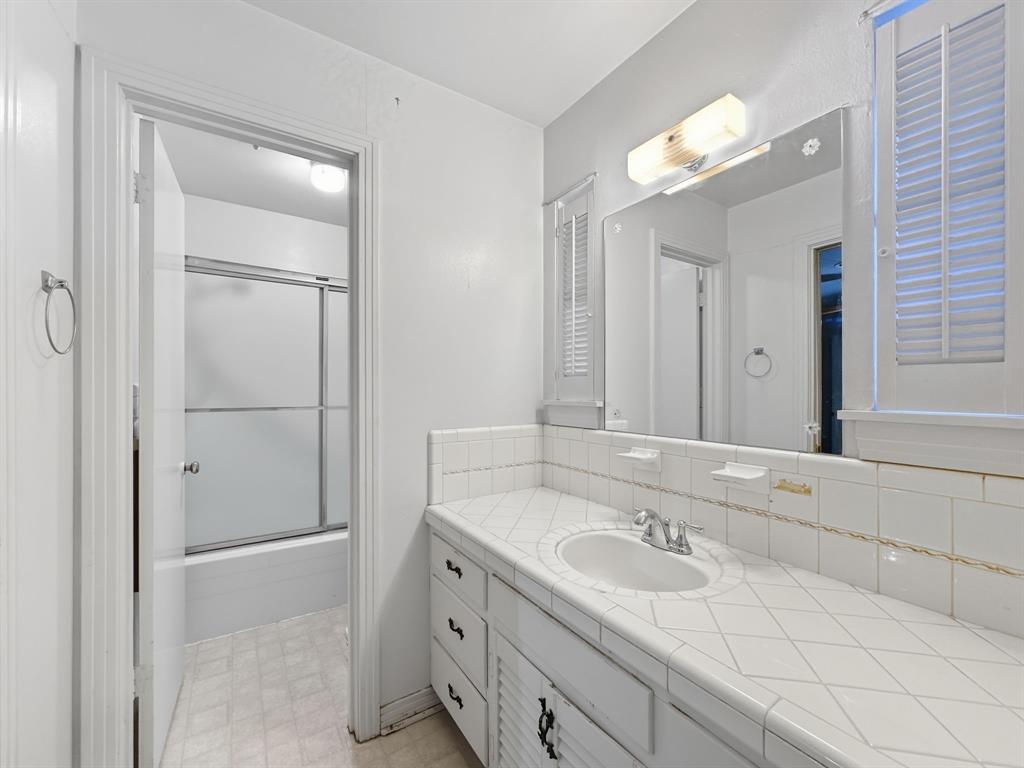 817 South Rusk Street Gainesville, TX 76240 - Photo 11 of 25 a bathroom with a sink and a mirror