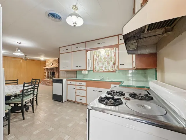 a kitchen with a sink a stove and chairs
