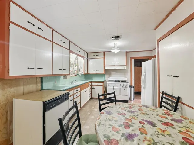 a kitchen with stainless steel appliances granite countertop a sink refrigerator and cabinets