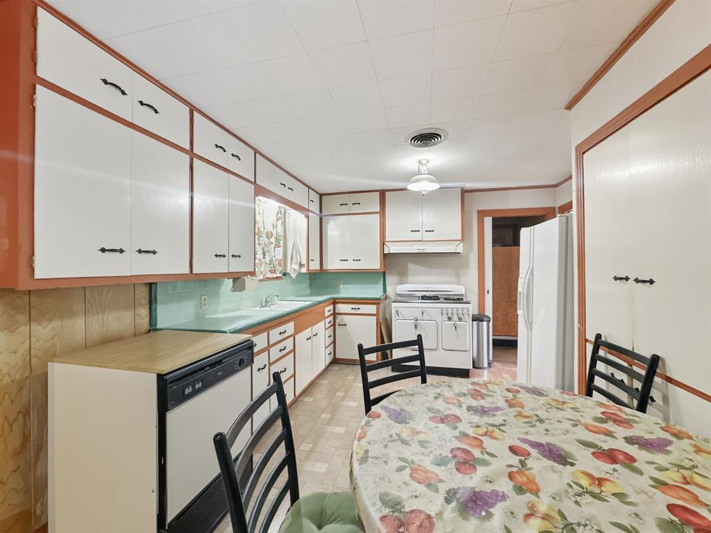 817 South Rusk Street Gainesville, TX 76240 - Photo 16 of 25 a kitchen with stainless steel appliances granite countertop a sink refrigerator and cabinets