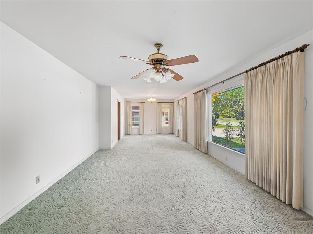 817 South Rusk Street Gainesville, TX 76240 - Photo 18 of 25 an empty room with chandelier fan and windows