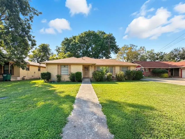 a front view of a house with yard and green space