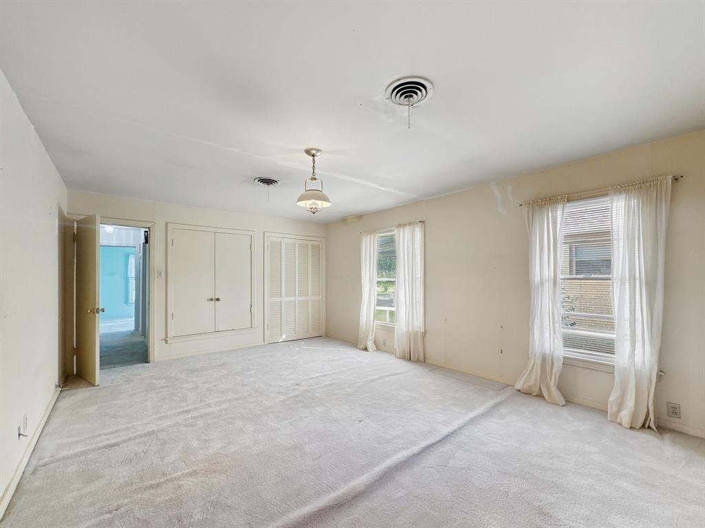 817 South Rusk Street Gainesville, TX 76240 - Photo 9 of 25 an empty room with closet and windows