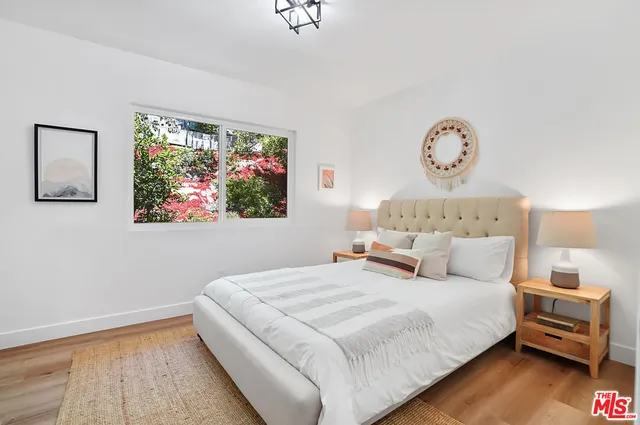 a bedroom with a bed mirror and window