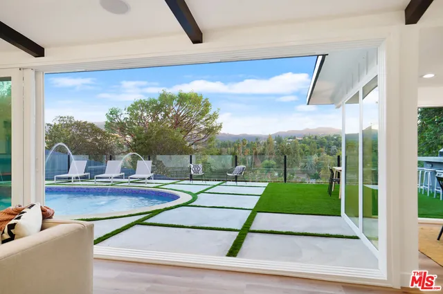 a view of a house with backyard and sitting area