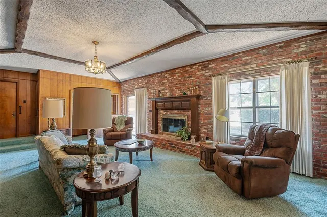 a living room with furniture a chandelier and a large window