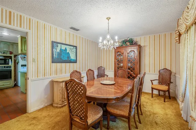 a view of a dining room with furniture and chandelier