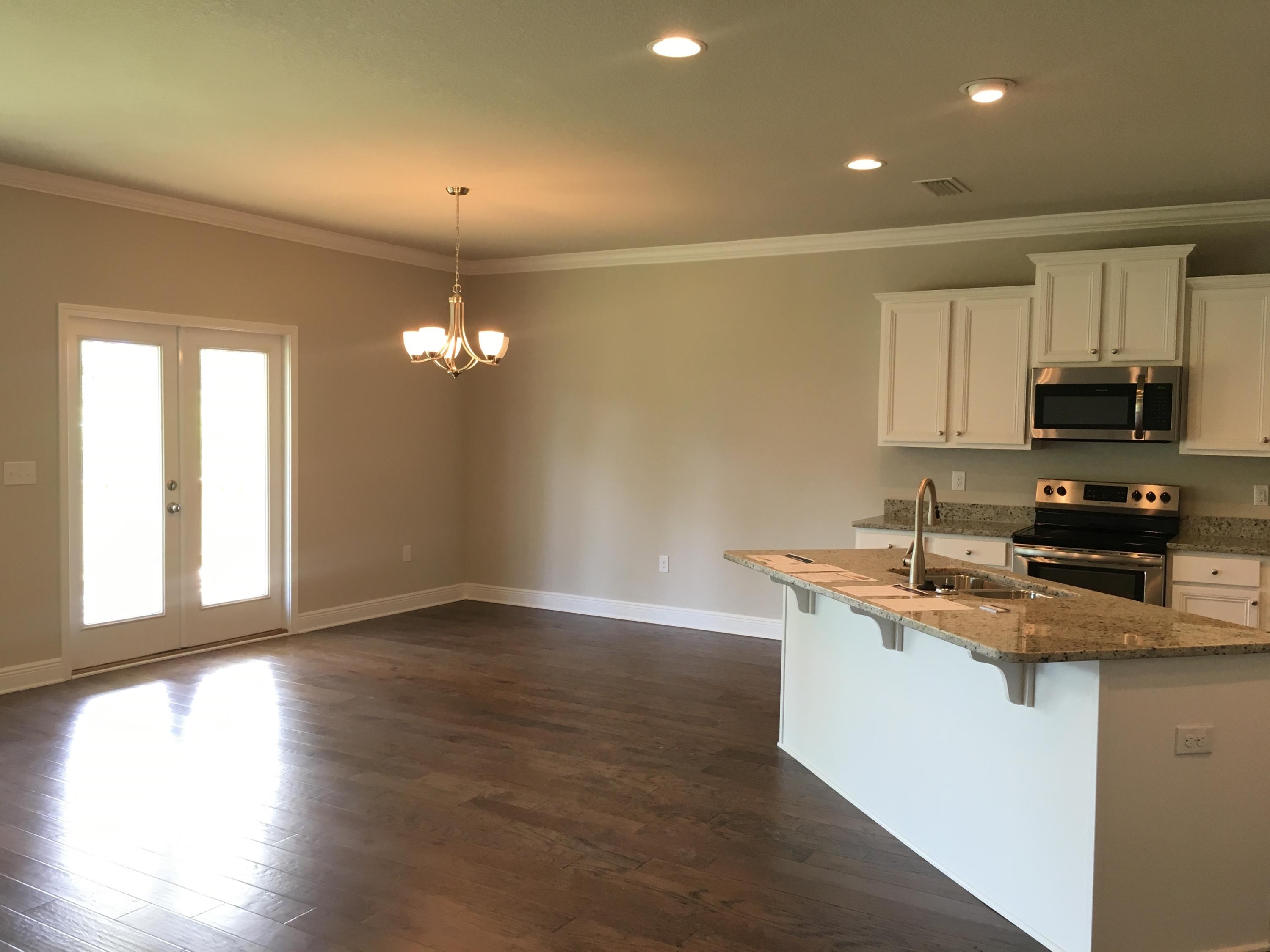590 Las Roblas Grande Drive Santa Rosa Beach, FL 32459 - Photo 16 of 20 a kitchen with granite countertop a stove a sink a microwave and wooden floor