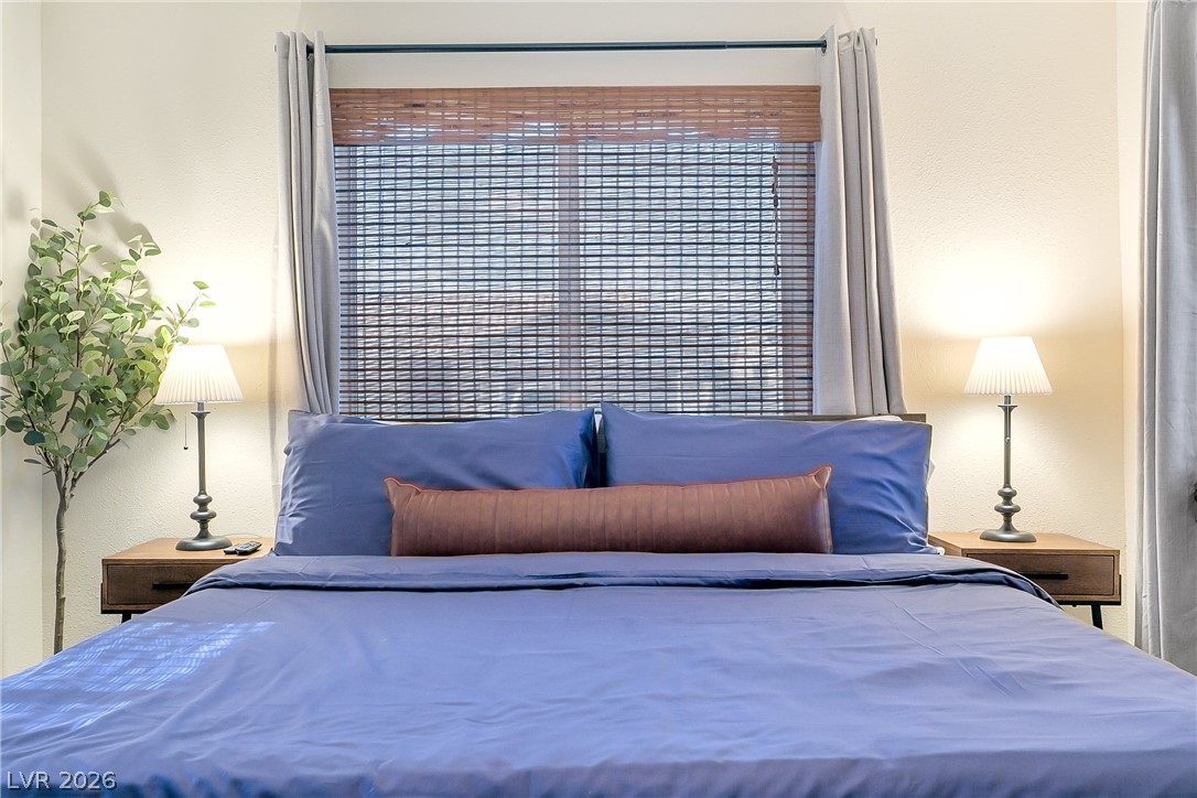 101 Beaver Ridge Avenue North Las Vegas, NV 89031 - Photo 18 of 42 Relax in this tranquil sleeping space, featuring a window with stylish woven blinds and soft drapes.