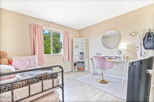 a spacious bedroom with a bed a mirror and desk