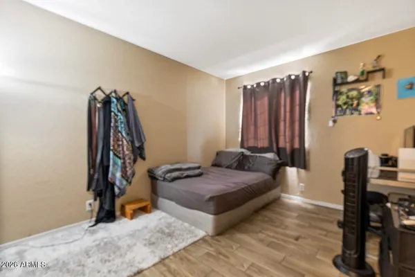 a living room with furniture a flat screen tv and a refrigerator