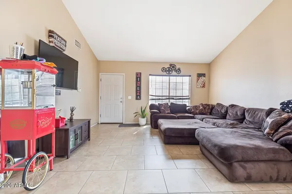a living room with furniture a flat screen tv and a window