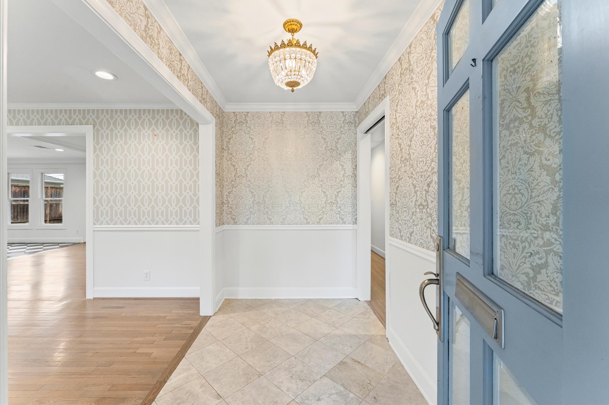 6158 Burgoyne Road Houston, TX 77057 - Photo 3 of 39 Cozy entry, the space transition from tiled flooring to hardwood, leading into a bright room with large windows.