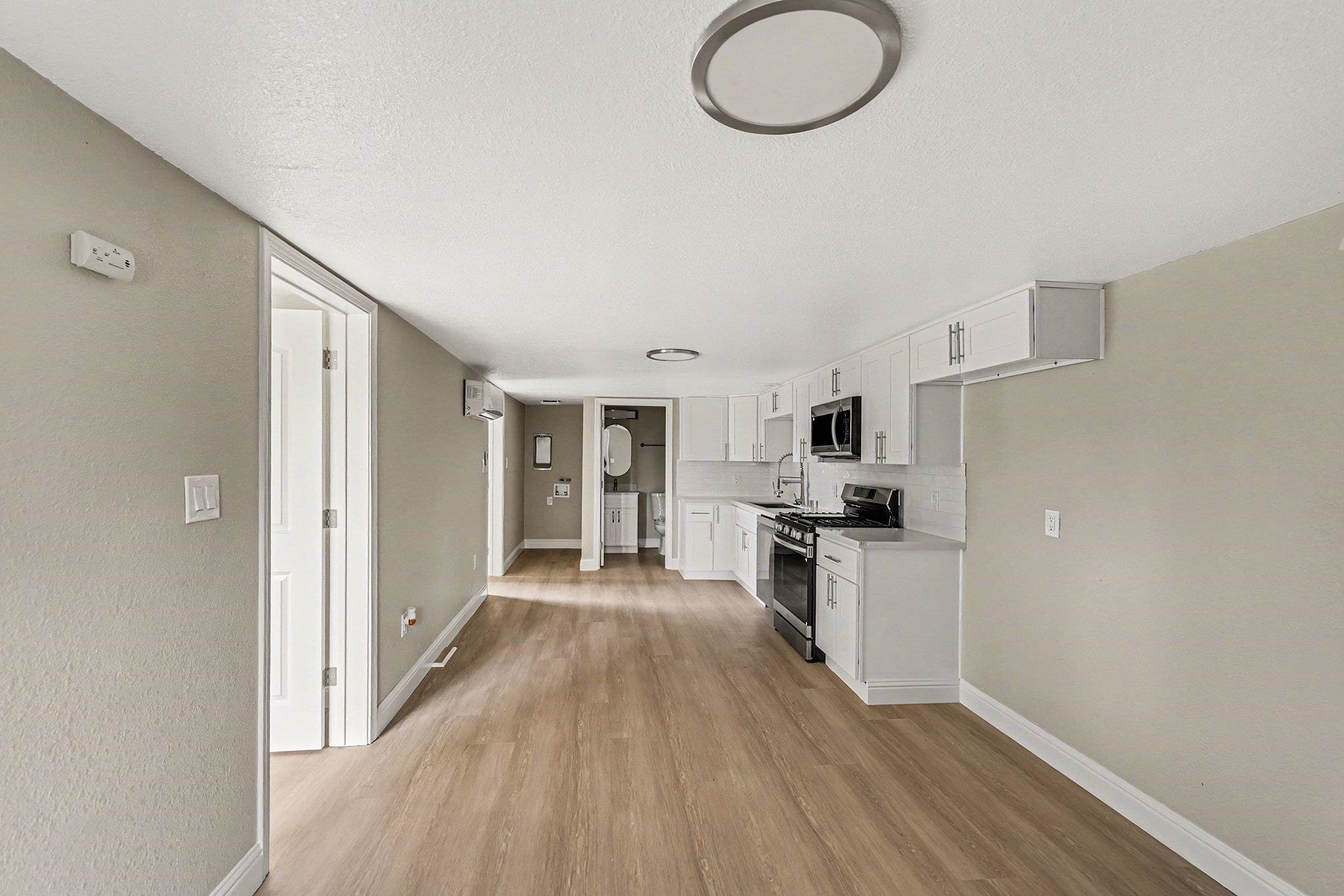 6 Lake Street Pittsburg, CA 94565 - Photo 14 of 29 a kitchen with granite countertop a stove top oven a sink dishwasher and a refrigerator with wooden floor