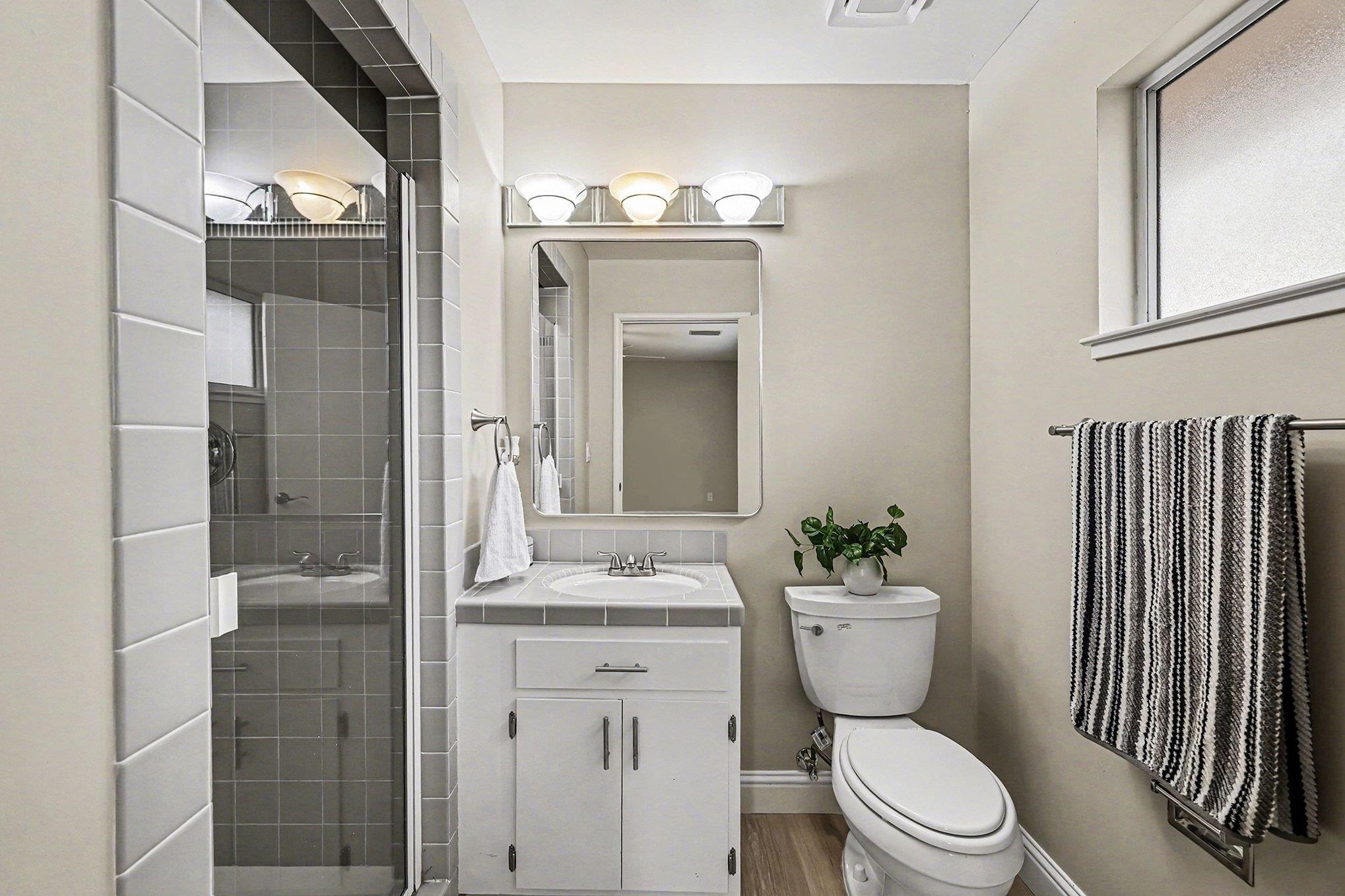 6 Lake Street Pittsburg, CA 94565 - Photo 19 of 29 a bathroom with a sink a toilet a mirror and shower