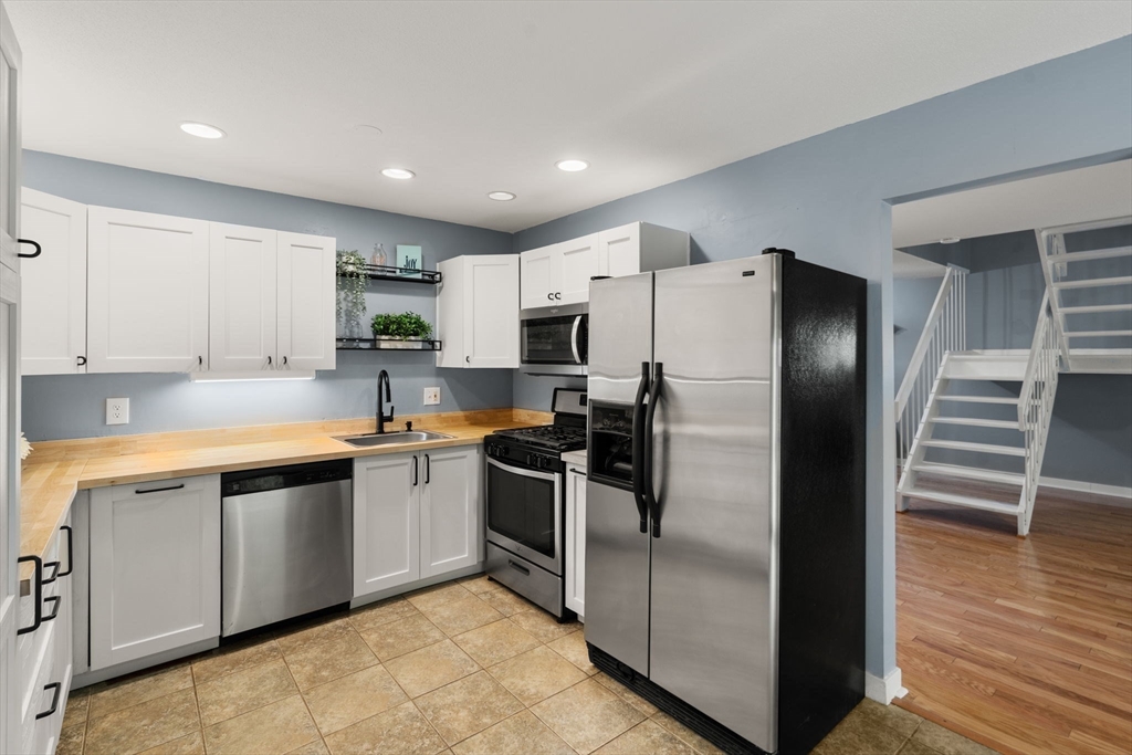 509 Dongary Road, Unit 509 Easton, MA 02375 - Photo 13 of 29 a kitchen with stainless steel appliances granite countertop a refrigerator a stove and a sink with wooden floor