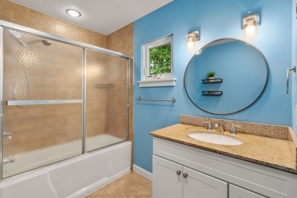 509 Dongary Road, Unit 509 Easton, MA 02375 - Photo 16 of 29 a bathroom with a granite countertop sink a mirror a vanity and shower