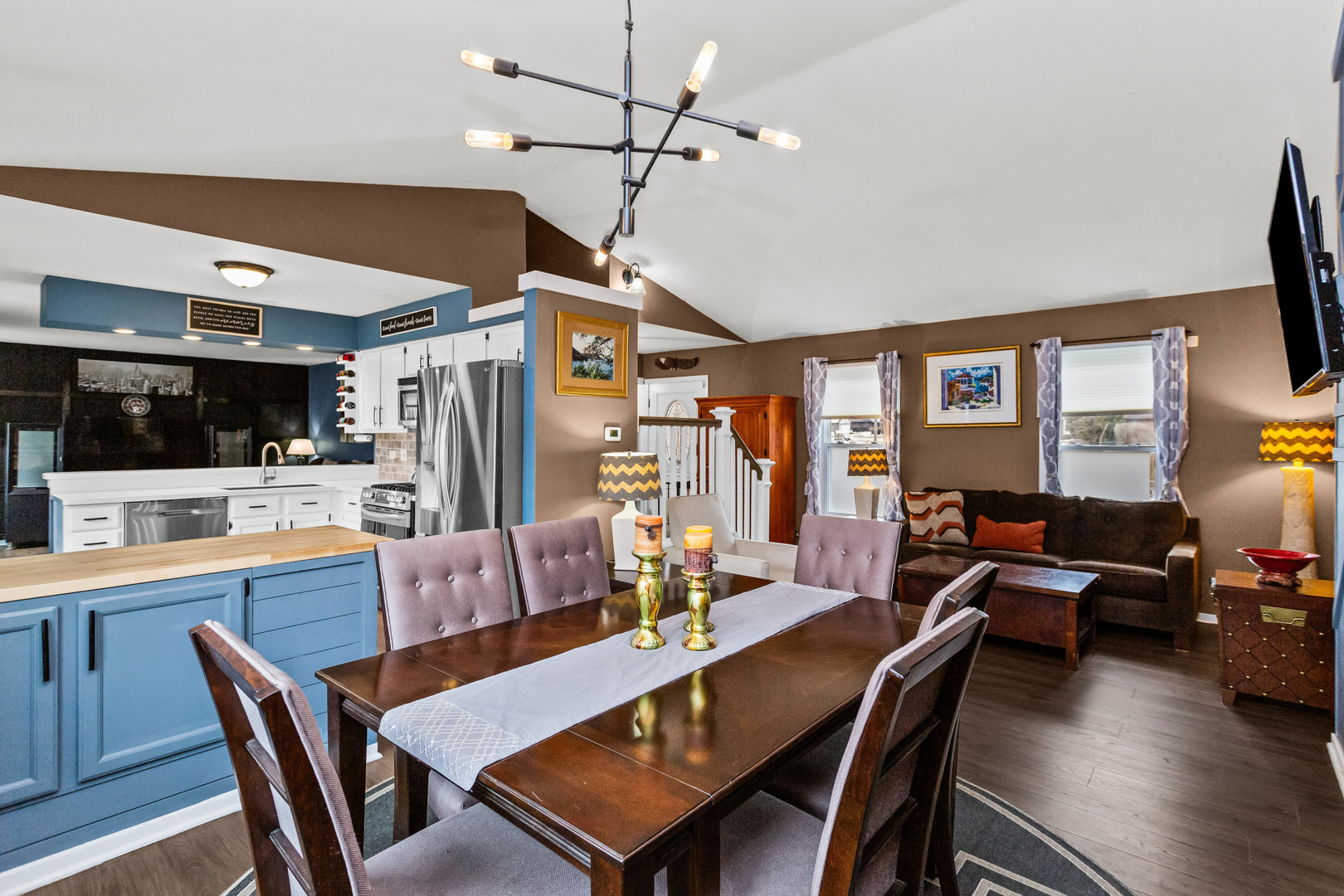 960 Mensching Road Roselle, IL 60172 - Photo 6 of 25 a dining room with furniture a kitchen a chandelier and a flat screen tv