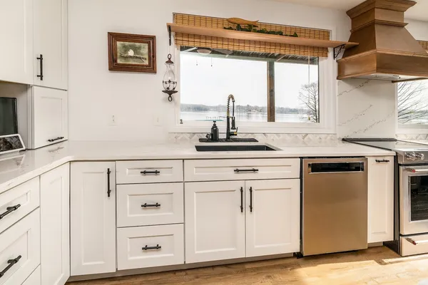 a kitchen with a sink a stove and a clock