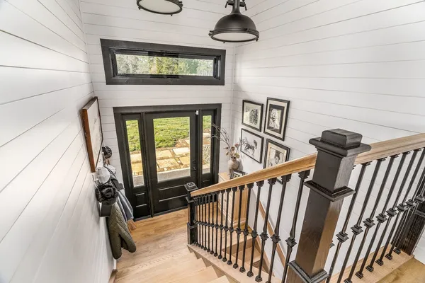 a view of a hallway with wooden floor and windows