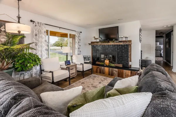 a living room with furniture a flat screen tv and a fireplace
