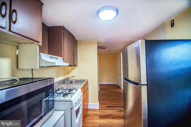a kitchen with a refrigerator and a stove top oven