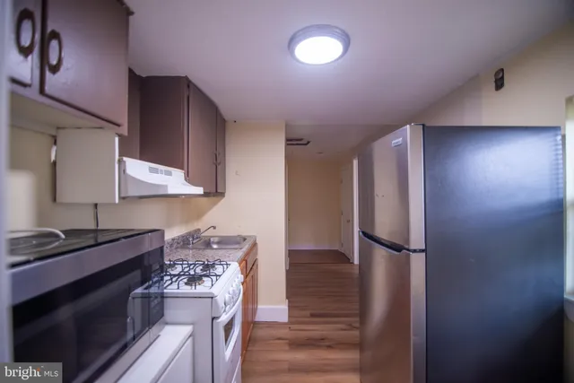 a kitchen with stainless steel appliances granite countertop a stove a refrigerator and a cabinets