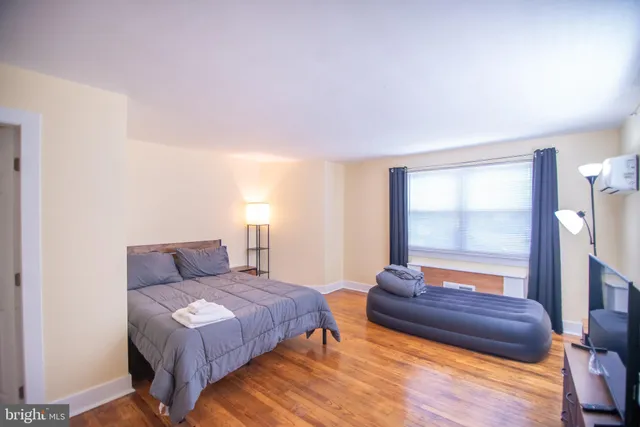 a bedroom with a bed and a large window