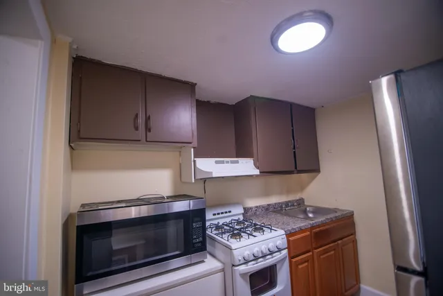 a kitchen with stainless steel appliances wooden cabinets and a stove a refrigerator