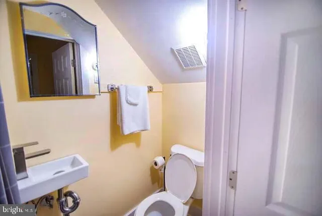 a bathroom with a sink mirror and toilet
