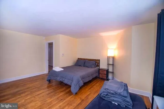 a bedroom with a bed and wooden floor