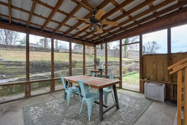 a dining room with furniture and a floor to ceiling window