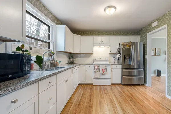 a kitchen with stainless steel appliances granite countertop a refrigerator and a stove top oven