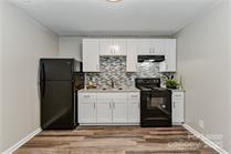 238 Hoskins Mill Lane, Unit D Charlotte, NC 28208 - Photo 9 of 13 a kitchen with a refrigerator and cabinets