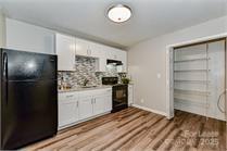 238 Hoskins Mill Lane, Unit D Charlotte, NC 28208 - Photo 10 of 13 a kitchen with a refrigerator and white cabinets