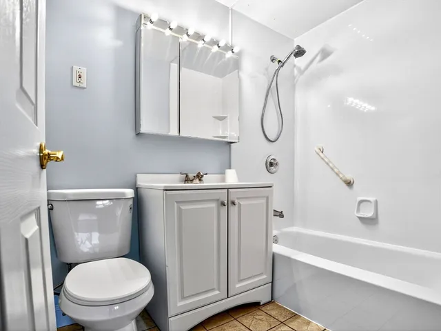 a bathroom with a granite countertop toilet a sink and bathtub