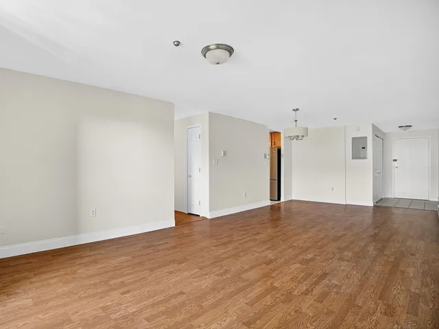 a view of an empty room with wooden floor