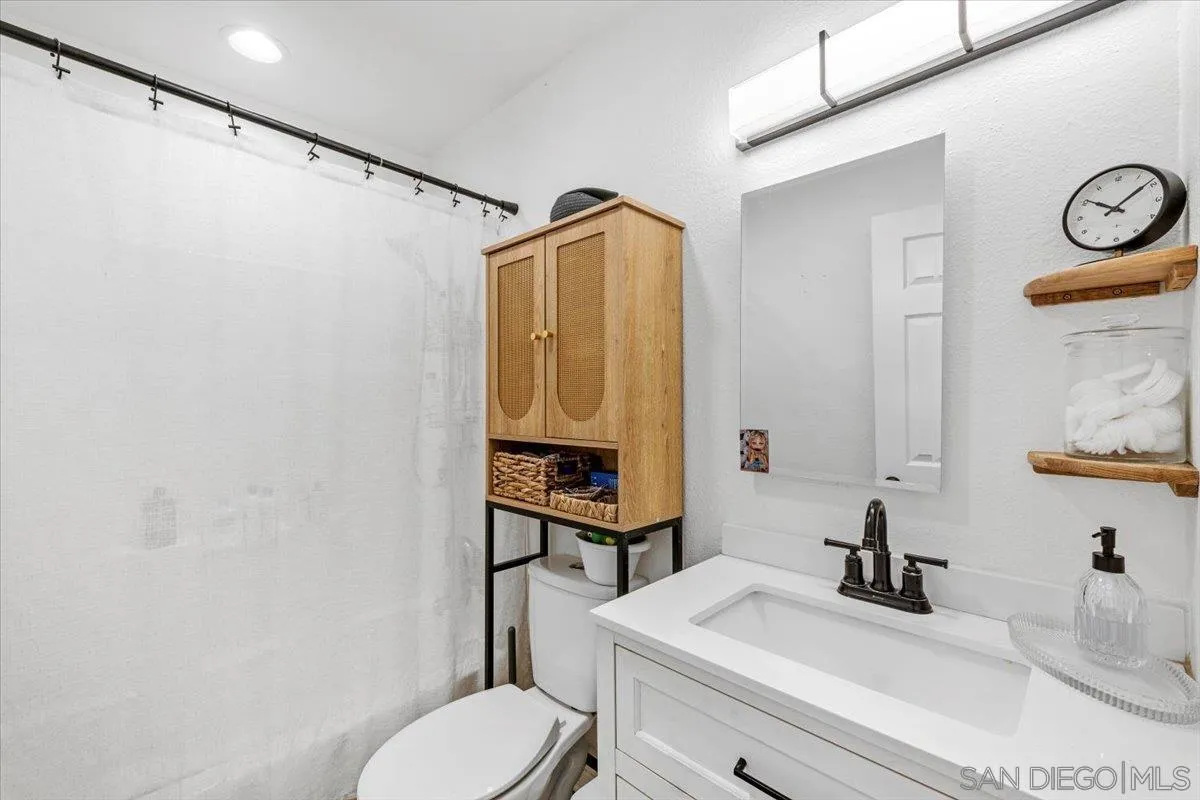 2127 Berry Street Lemon Grove, CA 91945 - Photo 13 of 25 a bathroom with a sink a toilet and a mirror