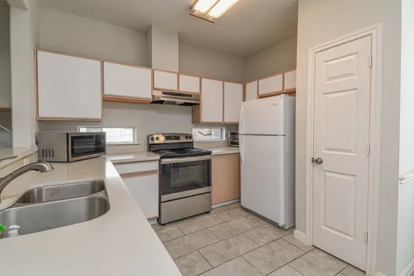 a kitchen with white cabinets and white appliances