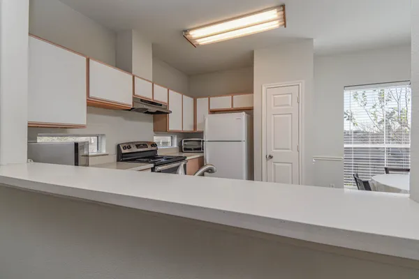 a kitchen with stainless steel appliances a sink a stove a refrigerator and cabinets