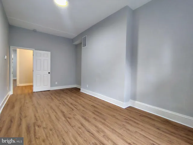 a view of an empty room with wooden floor
