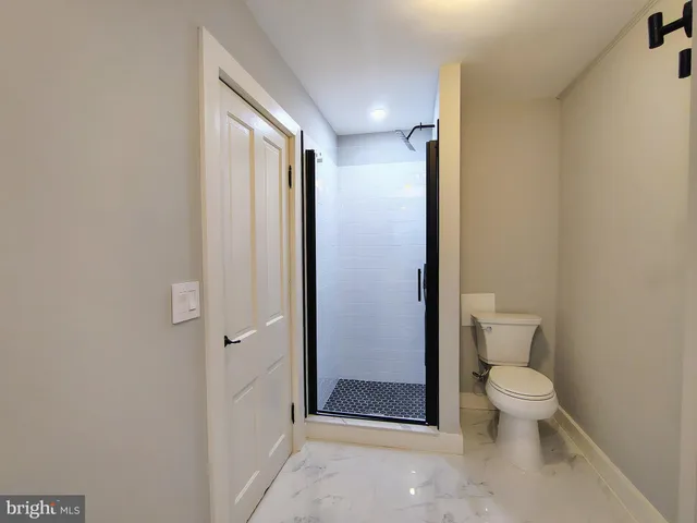 a bathroom with a granite countertop toilet and a shower