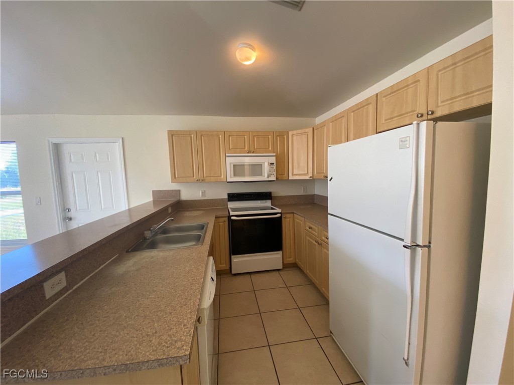 4622 15th Street Southwest Lehigh Acres, FL 33973 - Photo 4 of 15 a kitchen with a refrigerator a stove a sink dishwasher and a refrigerator