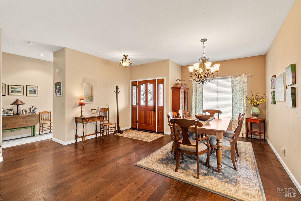 6252 Meadowstone Drive Santa Rosa, CA 95409 - Photo 18 of 33 a dining room with wooden floor a chandelier a glass table and chairs