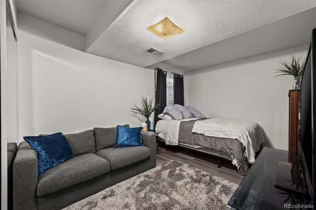 a bedroom with a bed couch and a potted plant