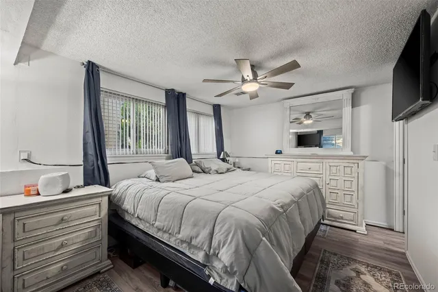 a bedroom with a large bed a flat tv screen and a dresser