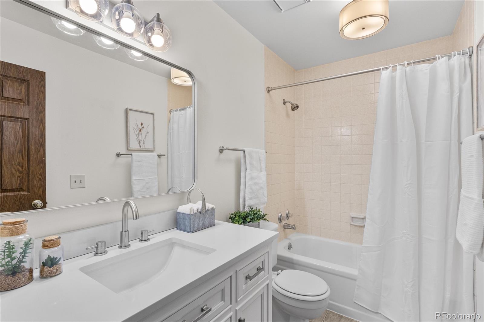 8441 Timberwood Street Highlands Ranch, CO 80126 - Photo 22 of 32 a bathroom with a sink a toilet a mirror a vanity and shower