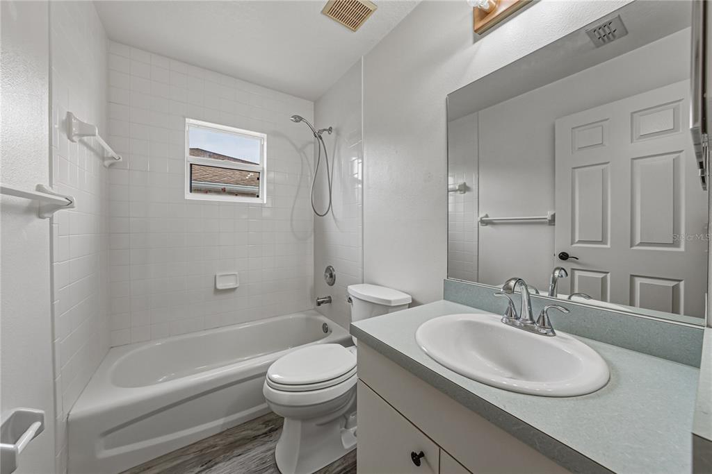 4752 Timber Way Zephyrhills, FL 33542 - Photo 36 of 46 a bathroom with a granite countertop sink toilet a mirror and bathtub