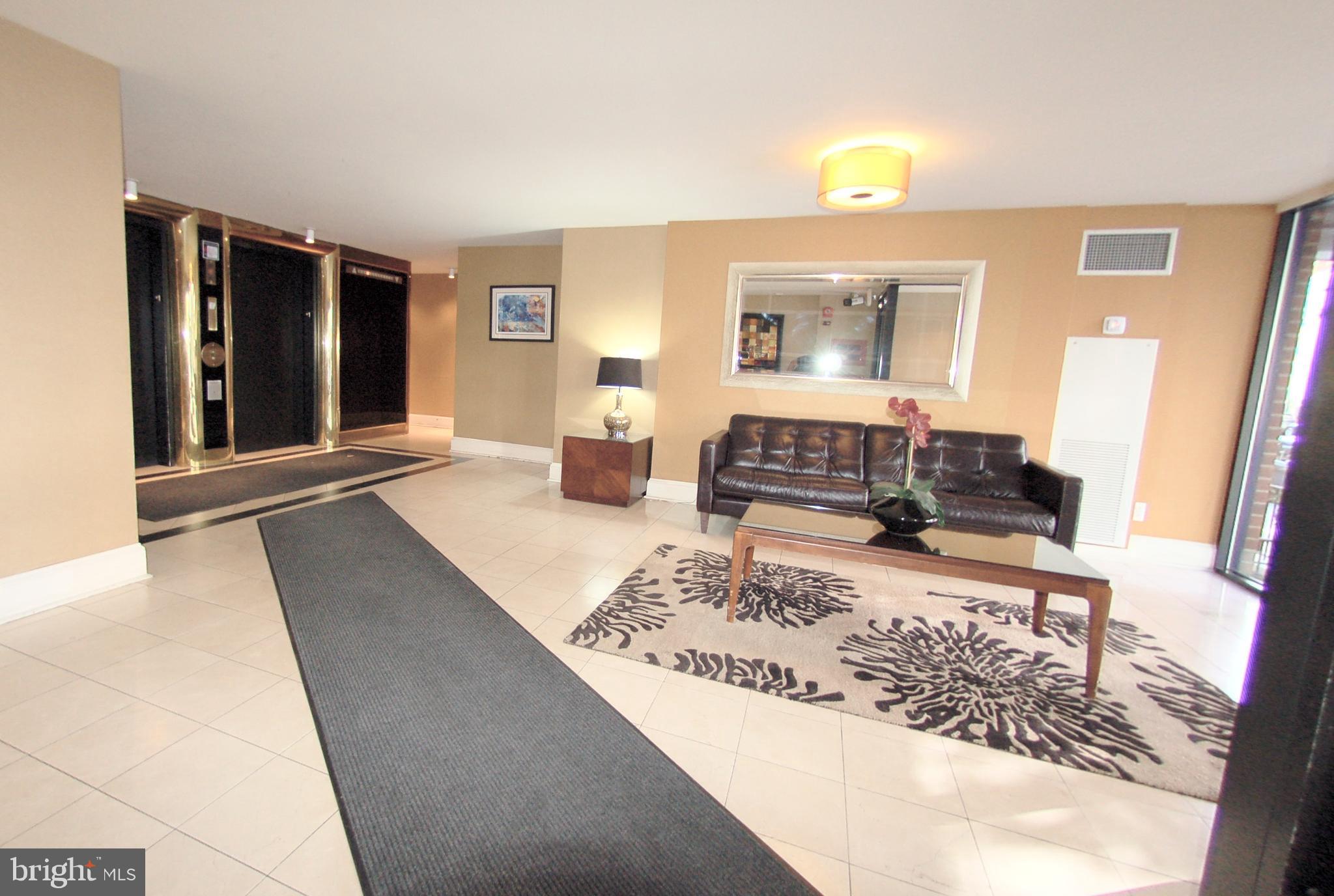 1245 13th Street Northwest, Unit 615 Washington, DC 20005 - Photo 12 of 18 a living room with a couch and a potted plant on the dresser